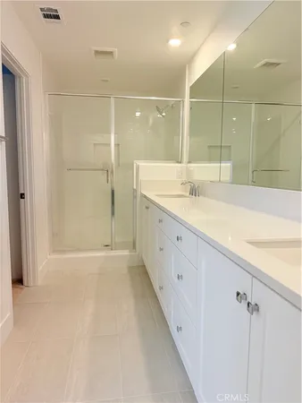 a bathroom with a granite countertop sink a large mirror and shower