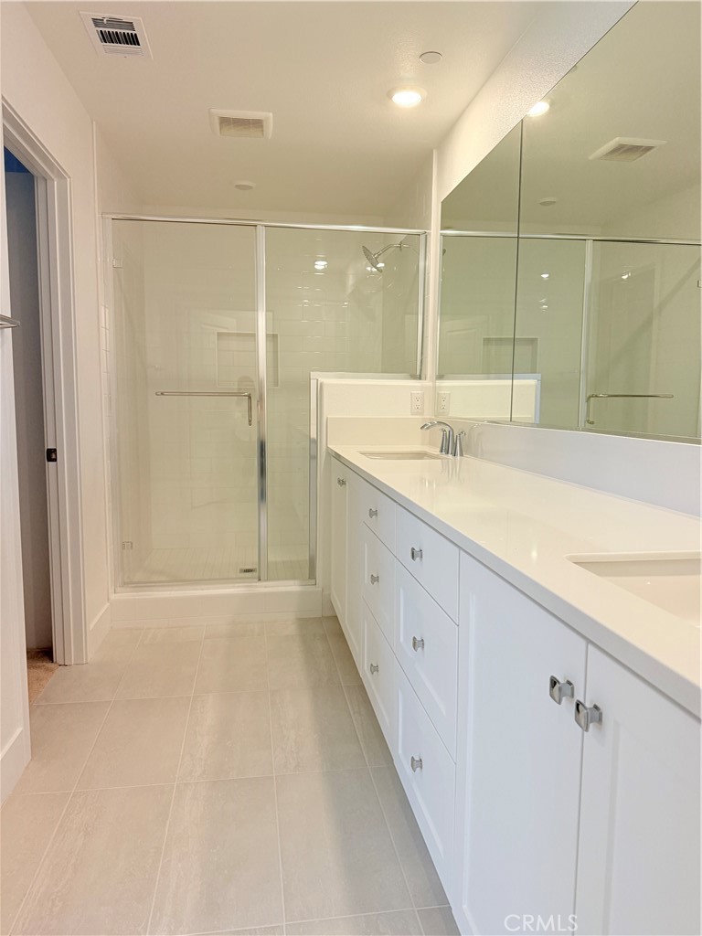 112 Junco Irvine, CA 92618 - Photo 11 of 17 a bathroom with a granite countertop sink a large mirror and shower