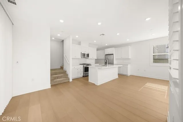 a view of a kitchen with furniture and refrigerator