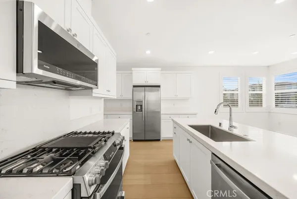 a kitchen with stainless steel appliances a sink a stove and a microwave