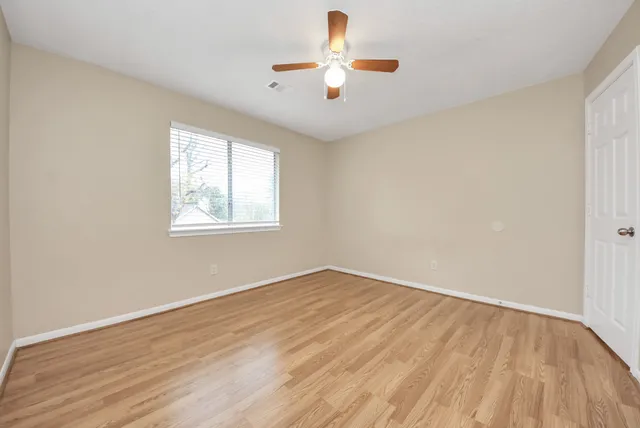 wooden floor in an empty room with a window