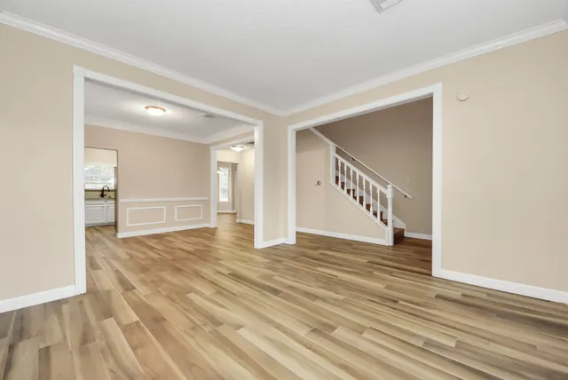 a view of an empty room with wooden floor and entryway