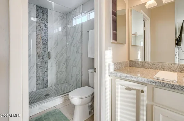 a bathroom with a granite countertop sink toilet and shower