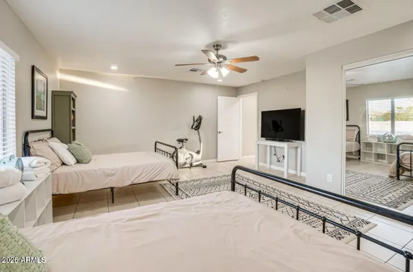 a spacious bedroom with a bed and a flat screen tv