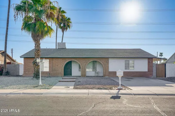 a front view of a house with garage and plants