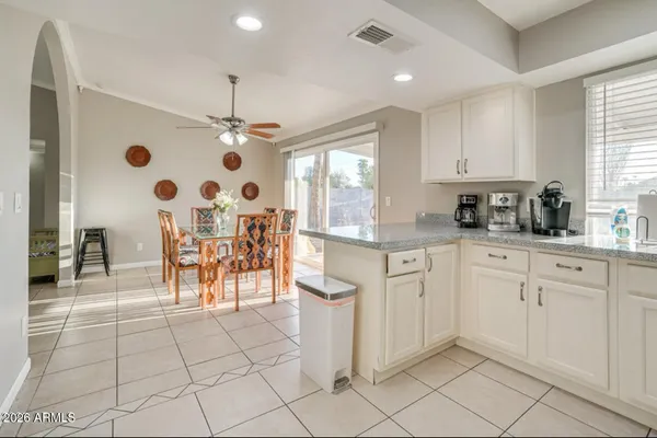 a open kitchen with white cabinets and white appliances