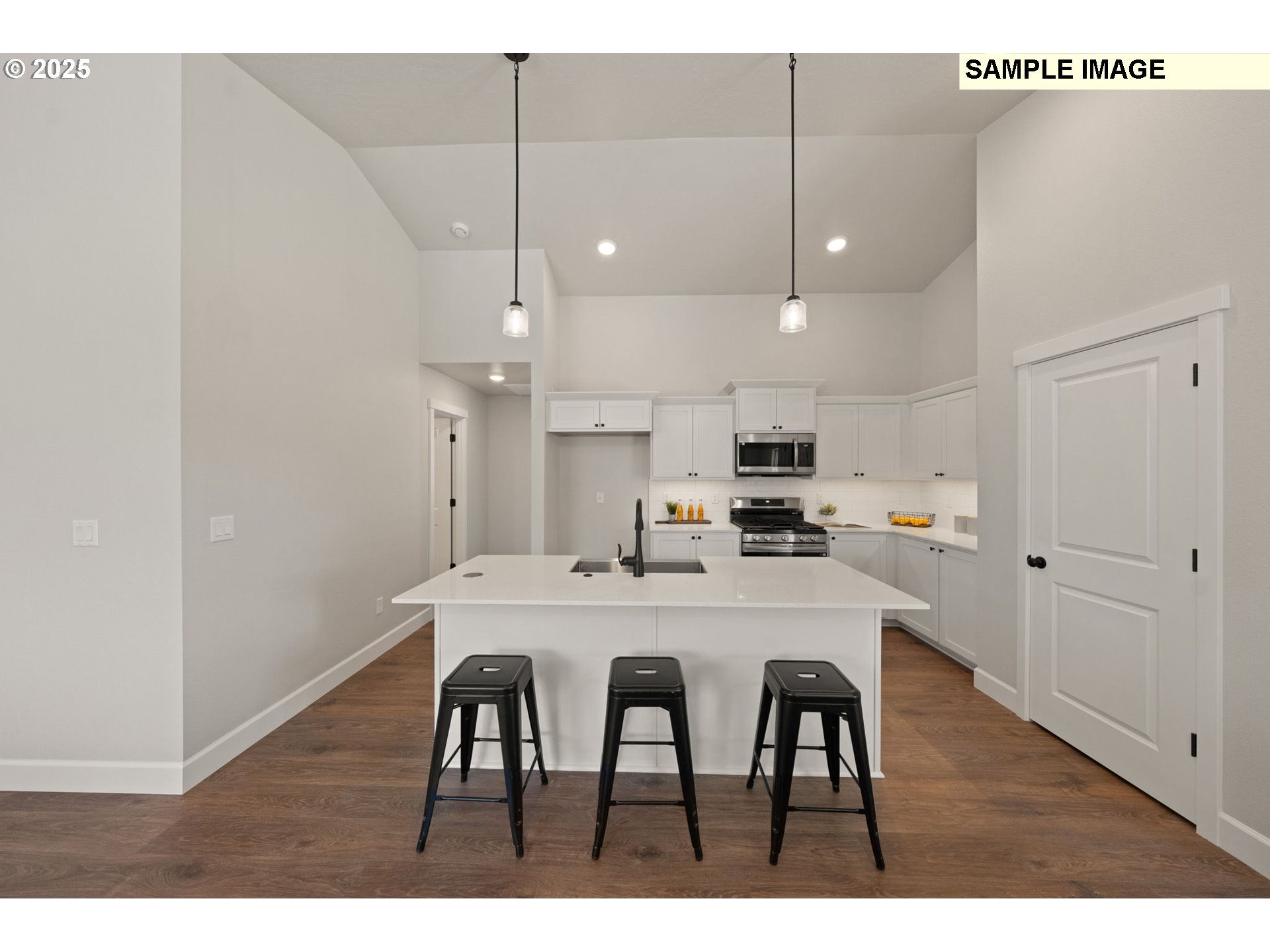 562 Taft Street Umatilla, OR 97882 - Photo 9 of 28 a kitchen with kitchen island a dining table chairs and white cabinets