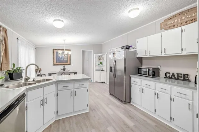 a kitchen with white cabinets and refrigerator