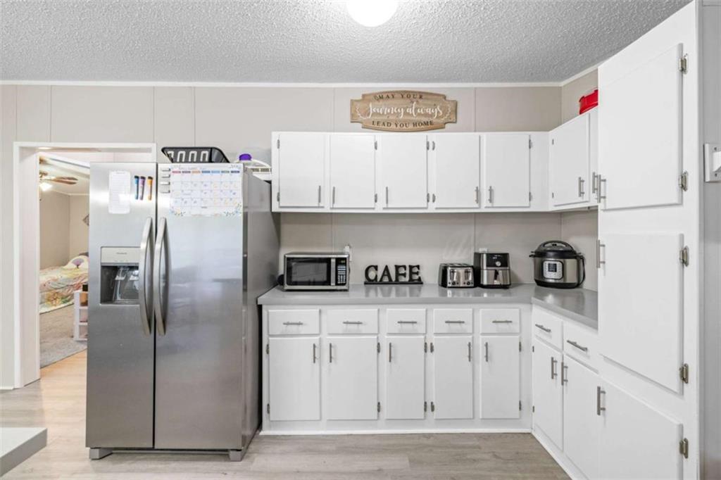 126 Loggins Trail Commerce, GA 30529 - Photo 15 of 50 a kitchen with white cabinets and stainless steel appliances