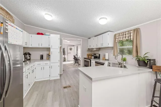 a kitchen with sink a refrigerator and cabinets