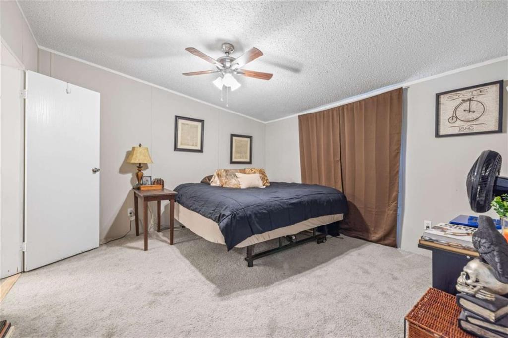 126 Loggins Trail Commerce, GA 30529 - Photo 20 of 50 a bedroom with a bed and a chandelier