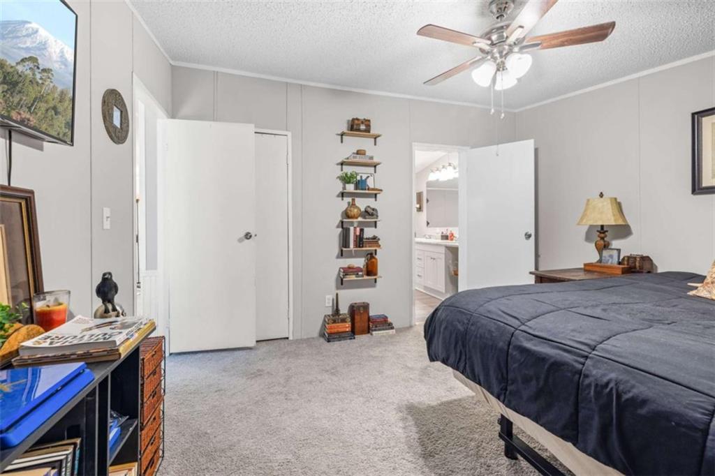 126 Loggins Trail Commerce, GA 30529 - Photo 21 of 50 a bedroom with a bed and a chandelier