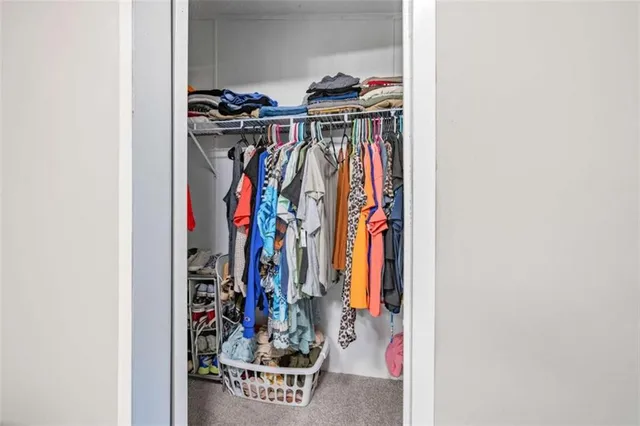 a view of walk in closet with clothes