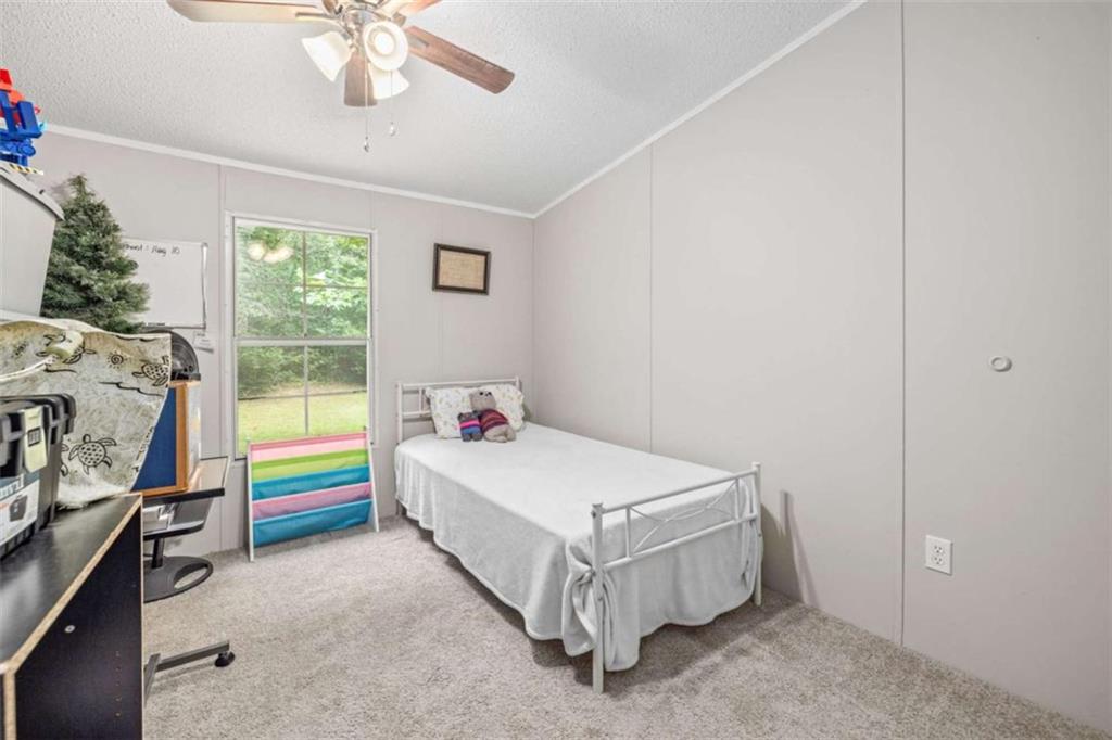 126 Loggins Trail Commerce, GA 30529 - Photo 28 of 50 a bedroom with a bed and a chandelier