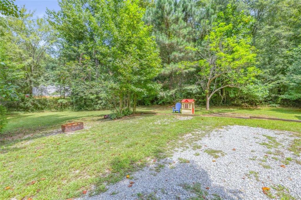 126 Loggins Trail Commerce, GA 30529 - Photo 32 of 50 a green field with lots of trees in the background
