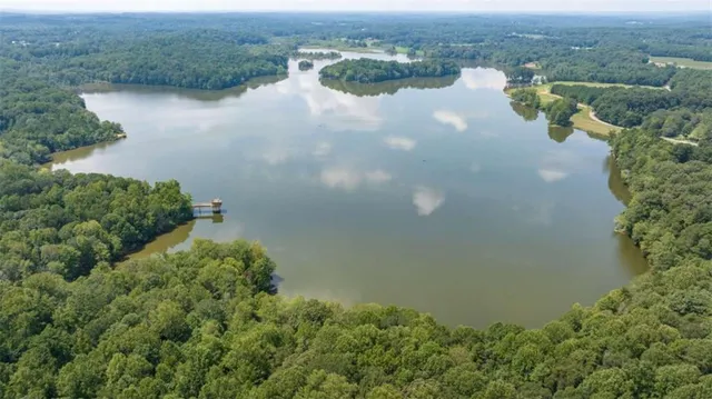 an aerial view of lake residential house with outdoor space and trees around