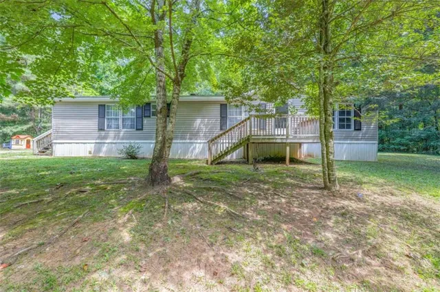 a view of a house with backyard and a tree