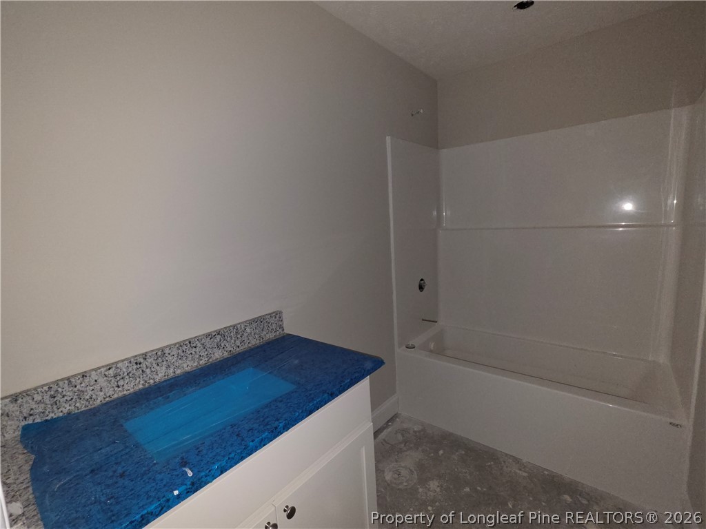 756 Jordan Road Autryville, NC 28318 - Photo 29 of 34 a bathroom with a granite countertop sink and a bathtub