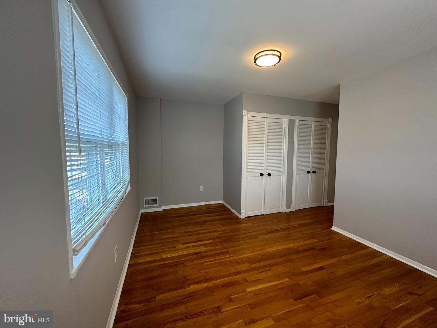 4116 Duke Street Alexandria, VA 22304 - Photo 14 of 16 a view of an empty room with wooden floor and a window