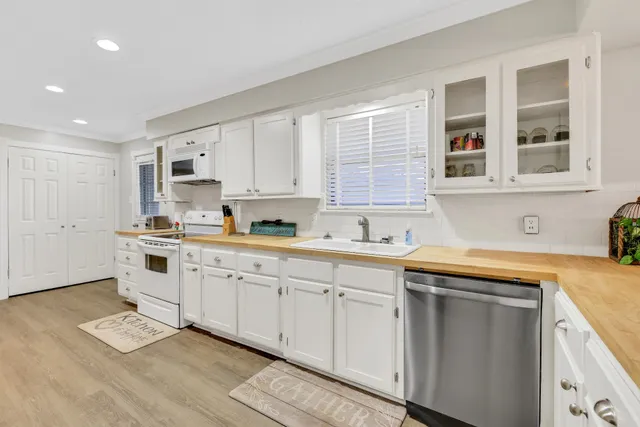 a kitchen with granite countertop white cabinets and white appliances