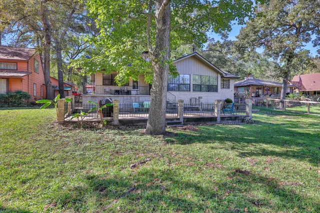a view of a backyard with table and chairs and a large tree