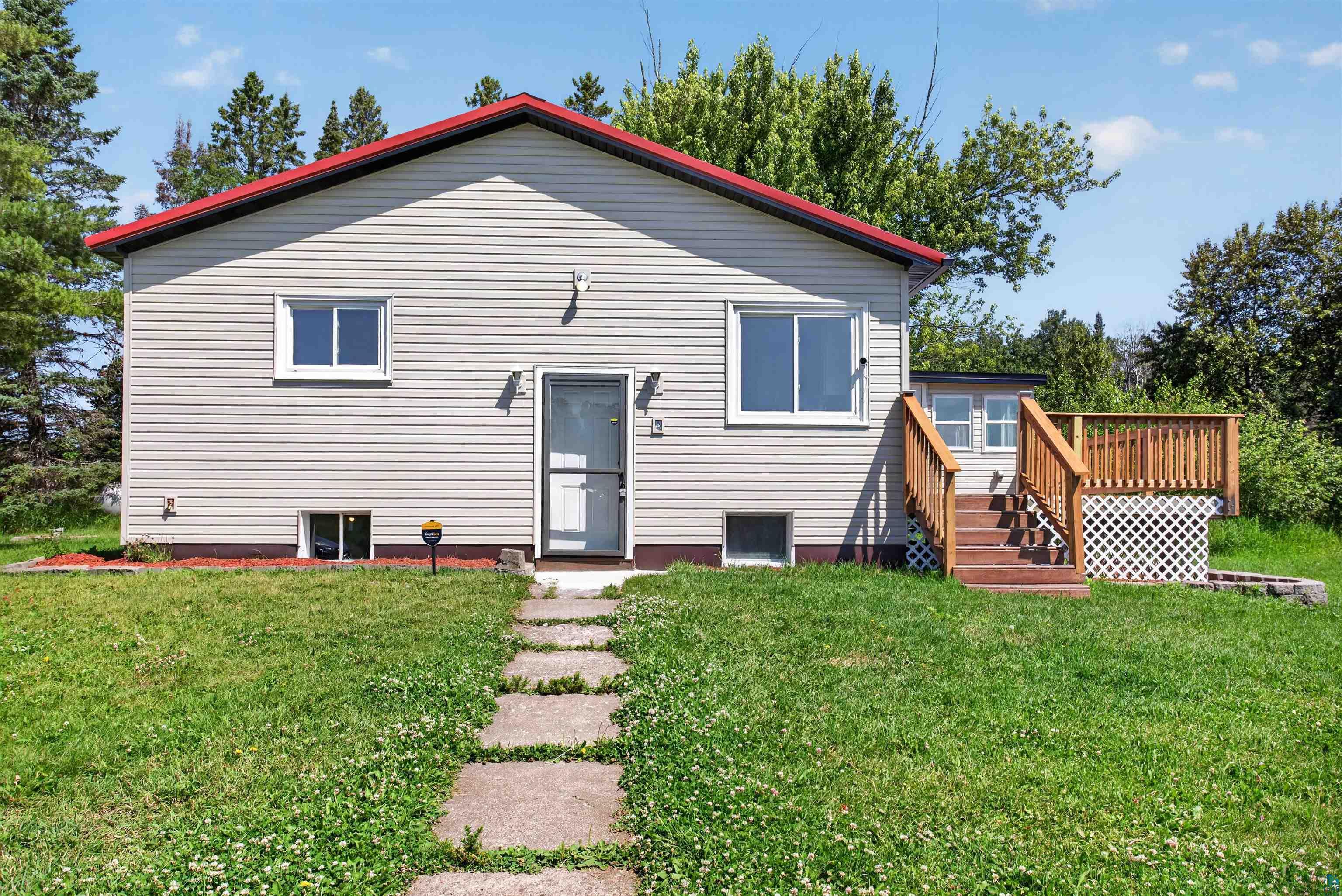 5868 Rice Lake Road Duluth, MN 55803 - Photo 2 of 39 Exterior featuring light-colored siding, a red roof, and a front entry with a storm door