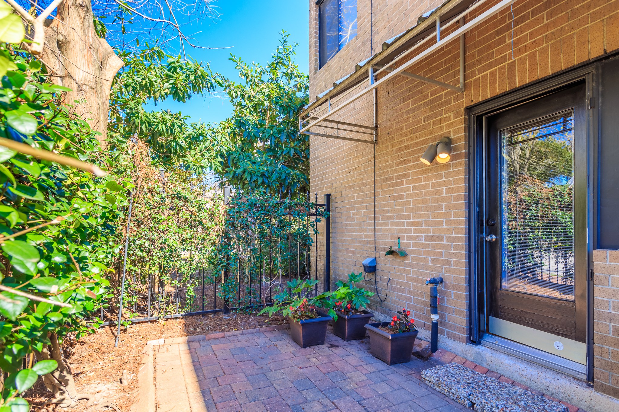 2349 Albans Road, Unit 1 Houston, TX 77005 - Photo 1 of 14 Charming outdoor patio with brick walls, and a glass door leading inside. Perfect for relaxing in a private, green setting.
