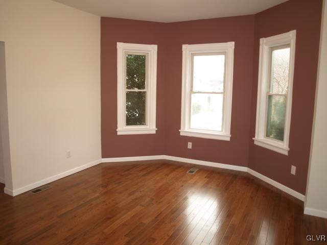 702 Spring Street Bethlehem, PA 18018 - Photo 6 of 17 an empty room with wooden floor and windows