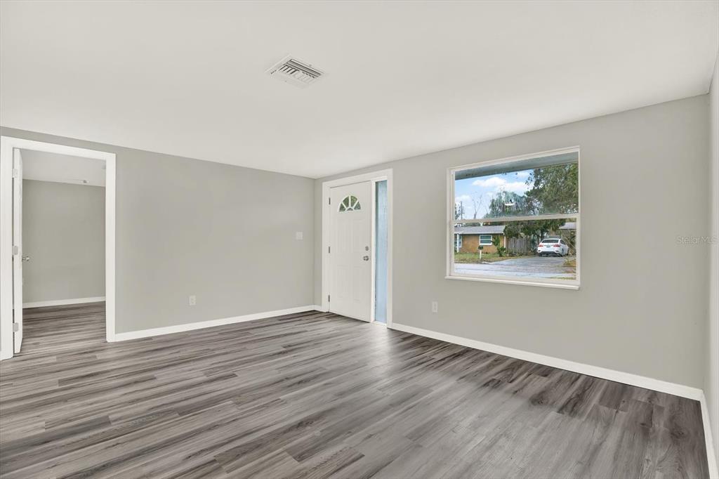 5038 Galaxy Drive New Port Richey, FL 34652 - Photo 11 of 32 a view of an empty room with wooden floor and a window