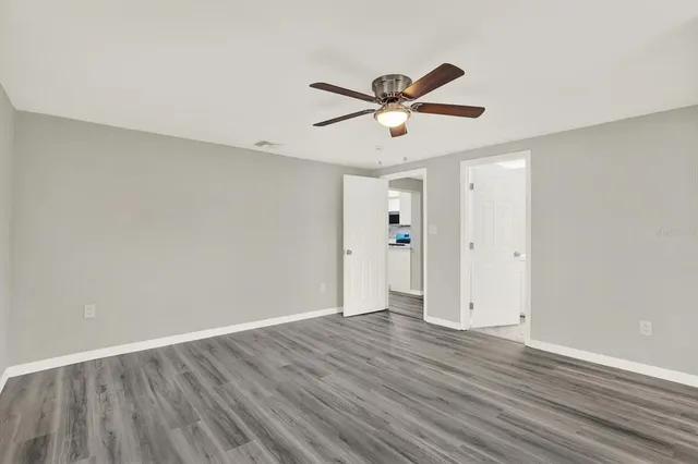 an empty room with wooden floor and windows