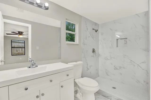 a bathroom with a sink toilet a mirror and shower