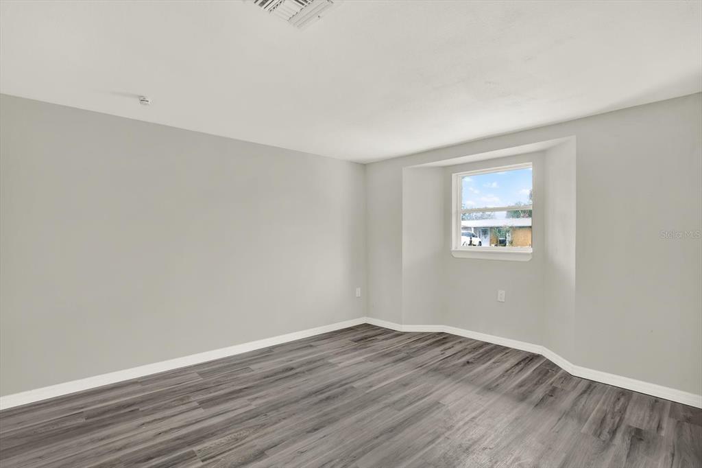 5038 Galaxy Drive New Port Richey, FL 34652 - Photo 21 of 32 an empty room with wooden floor and windows