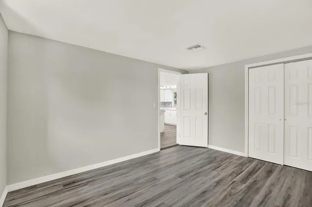 a view of an empty room with wooden floor