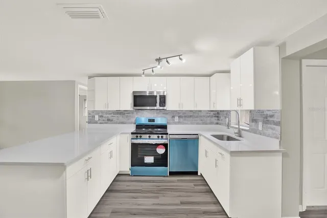 a kitchen with stainless steel appliances granite countertop a sink and stove