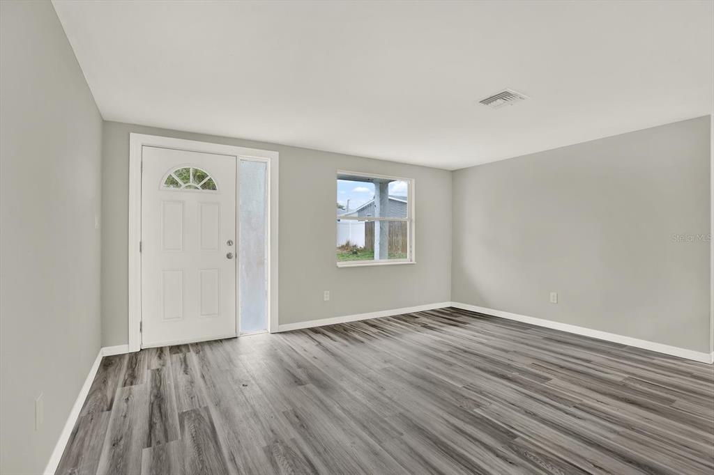 5038 Galaxy Drive New Port Richey, FL 34652 - Photo 10 of 32 a view of an empty room with wooden floor and a window