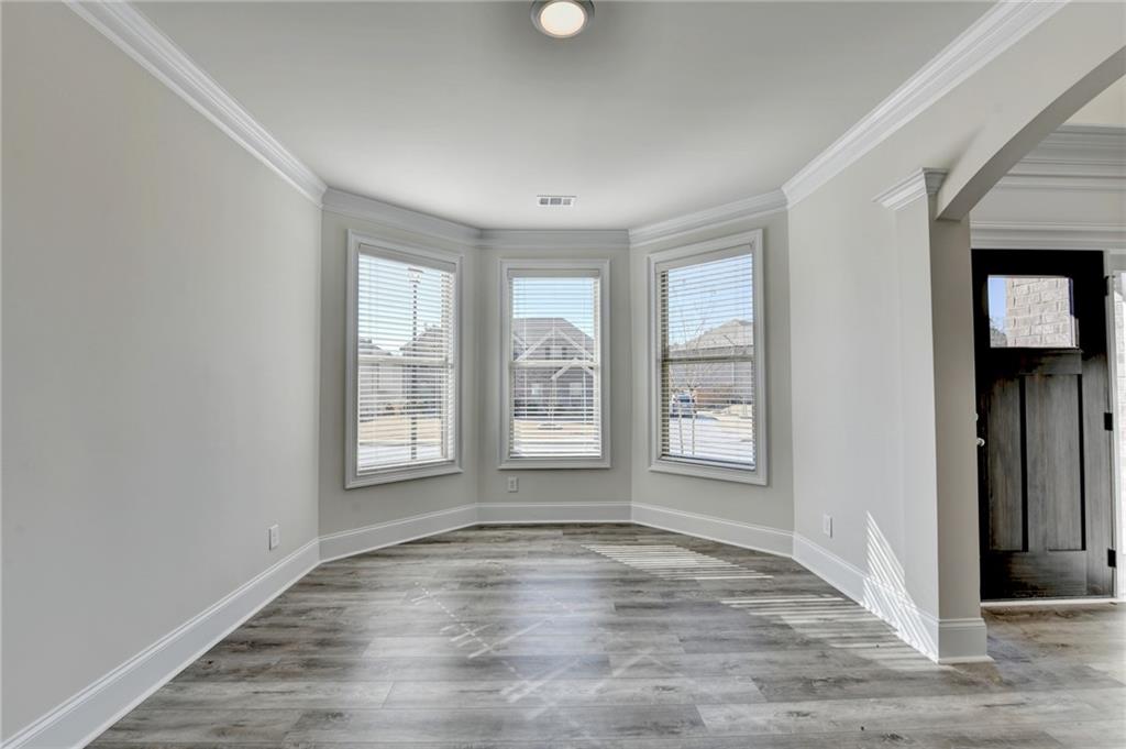1661 Silver Crest Way Hoschton, GA 30548 - Photo 11 of 57 an empty room with wooden floor and windows