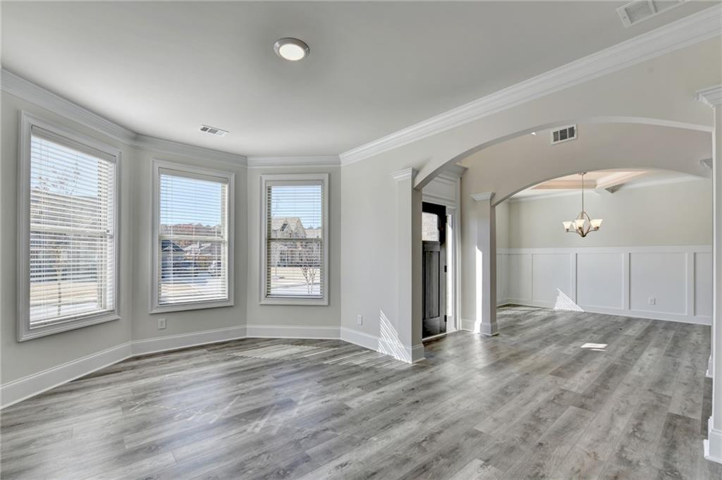 1661 Silver Crest Way Hoschton, GA 30548 - Photo 12 of 57 a view of an empty room with wooden floor and a window