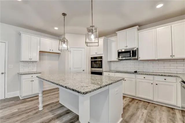 a kitchen with granite countertop white cabinets white appliances and granite counter tops