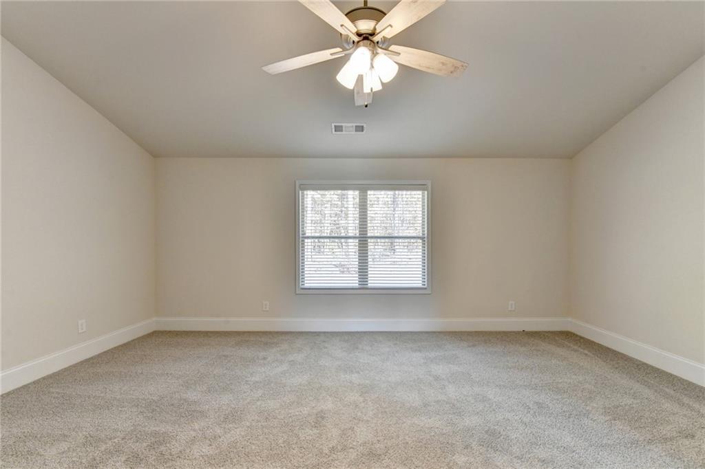 1661 Silver Crest Way Hoschton, GA 30548 - Photo 46 of 57 an empty room with a window and a chandelier fan
