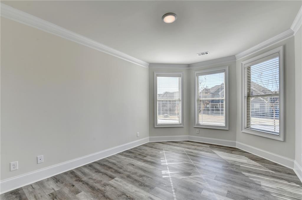 1661 Silver Crest Way Hoschton, GA 30548 - Photo 10 of 57 an empty room with wooden floor and windows