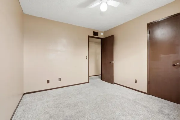 an empty room with a ceiling fan and a window