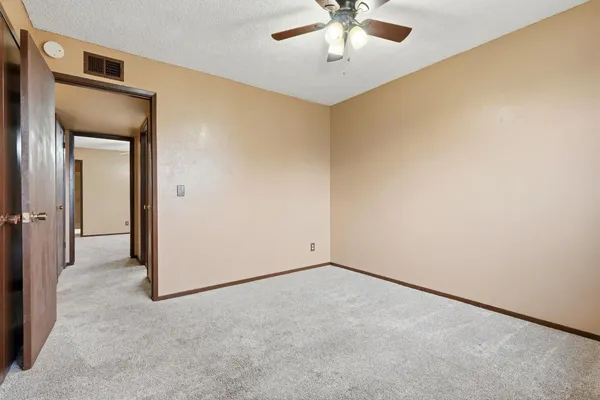 an empty room with a empty space and chandelier fan