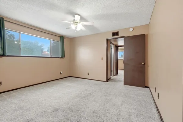 a view of an empty room with chandelier fan