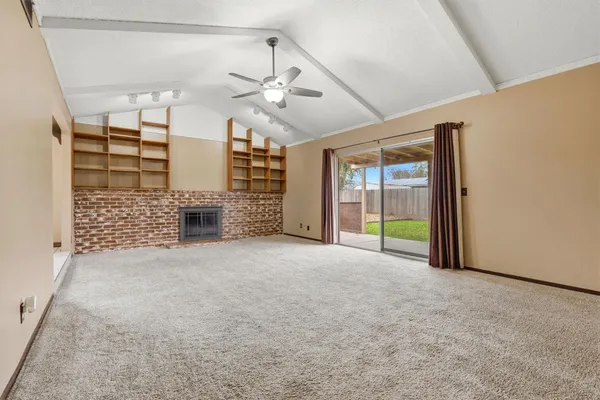 en empty room with windows and ceiling fan