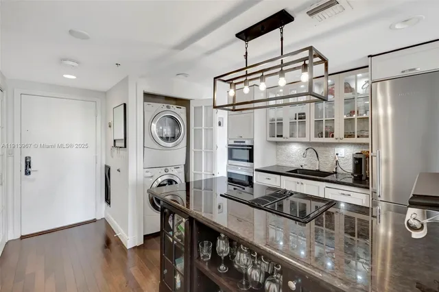 a kitchen with stainless steel appliances kitchen island a table and chairs in it