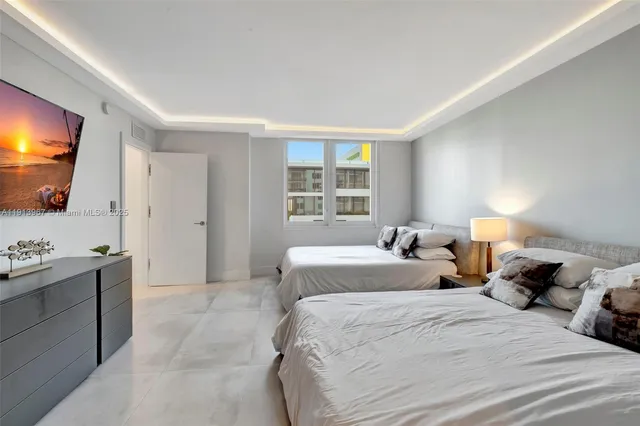 a bedroom with two beds and a window