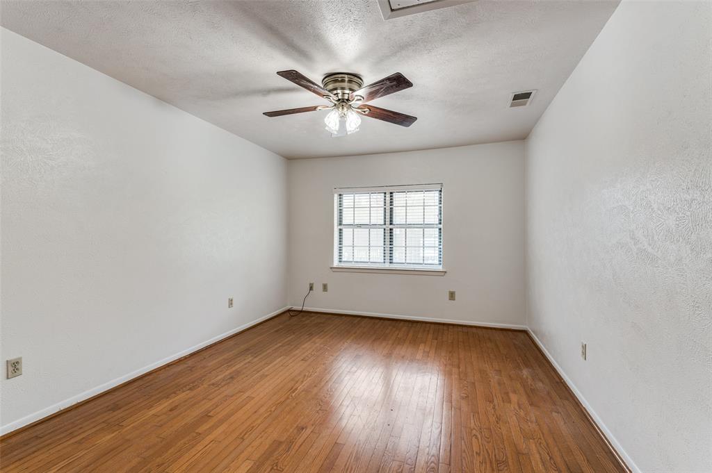 1230 Fairdale Street Irving, TX 75062 - Photo 14 of 24 Unfurnished room with hardwood / wood-style flooring, ceiling fan, a textured ceiling, and a textured wall