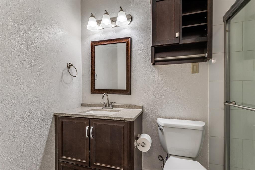 1230 Fairdale Street Irving, TX 75062 - Photo 18 of 24 Bathroom with a textured wall, vanity, and a shower stall