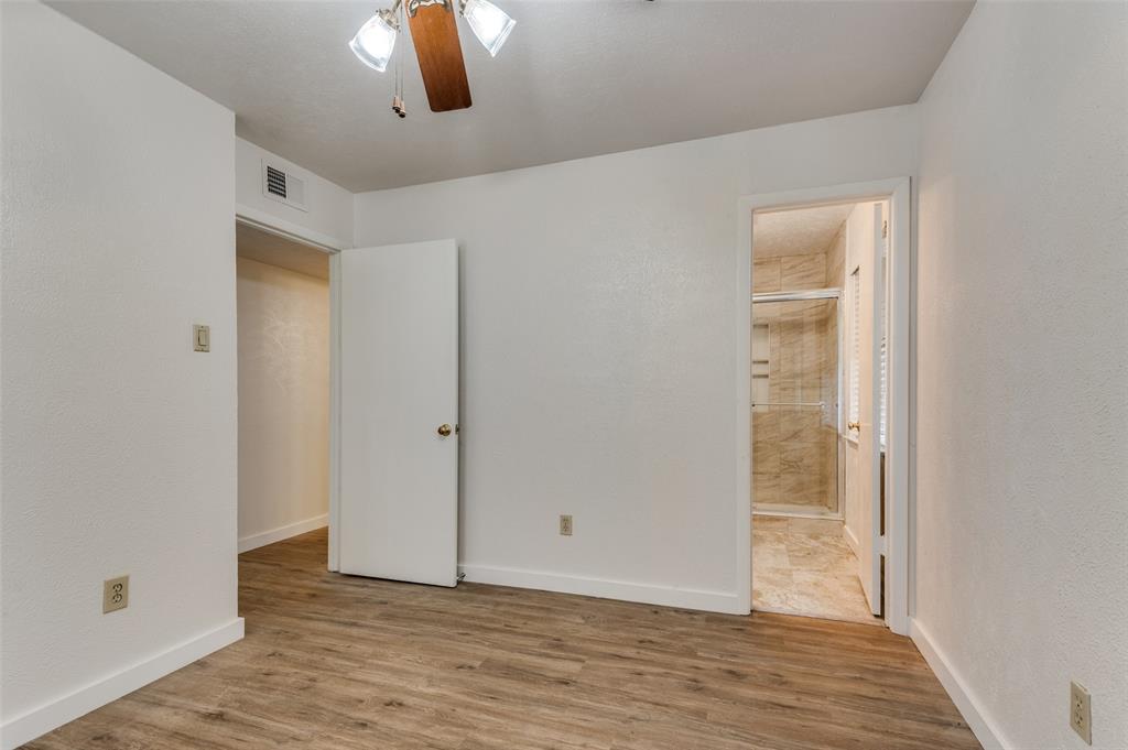 1230 Fairdale Street Irving, TX 75062 - Photo 20 of 24 Unfurnished bedroom featuring light wood-type flooring, ensuite bathroom, and a ceiling fan
