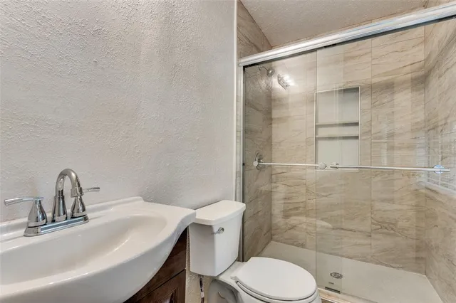 a bathroom with a sink toilet and shower